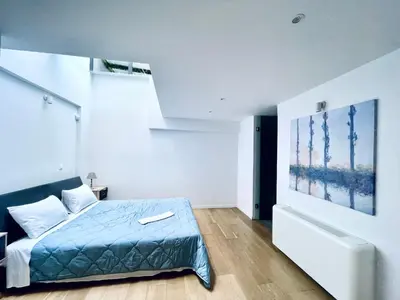 a bedroom with a blue bed in a white room at Athens Riviera, 2 Pools & Gym Luxury Residence 310m2 in Athens