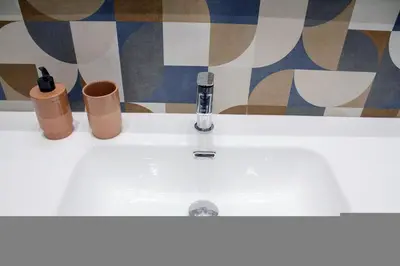 a bathroom sink with a faucet and two cups at Acropolis Luxury retreat in Athens