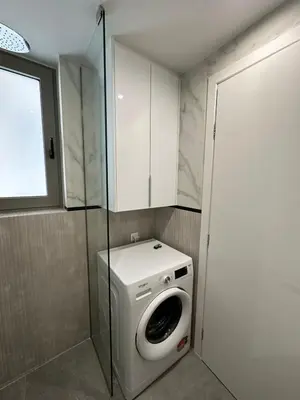 a washing machine in a bathroom with a glass door at Niarchos Elegant Maisonette in Athens
