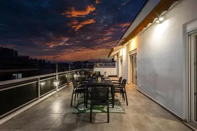 a balcony with a table and chairs on a roof at Traveler's Dream 3-Bedroom Renovated Penthouse in Athens