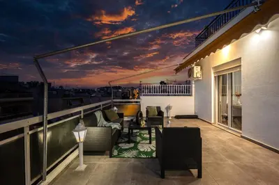 a balcony with a table and chairs on a building at Traveler's Dream 3-Bedroom Renovated Penthouse in Athens