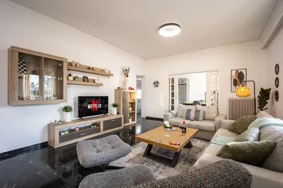 a living room with a couch and a tv at Traveler's Dream 3-Bedroom Renovated Penthouse in Athens