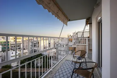 a balcony with two chairs and a table at Traveler's Dream 3-Bedroom Renovated Penthouse in Athens