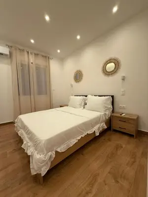 a bedroom with a large bed and a mirror on the wall at Byron cozy brand new apartment in Athens