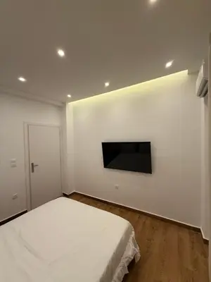 a bedroom with a bed and a tv on a wall at Byron cozy brand new apartment in Athens