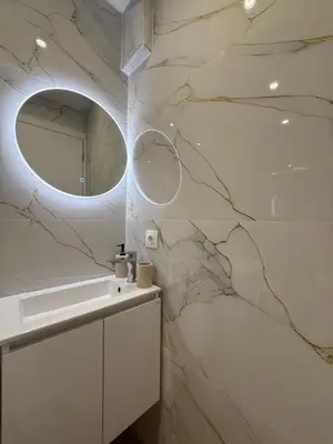 a bathroom with a marble wall with a mirror at Byron cozy brand new apartment in Athens