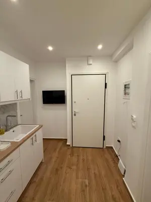 a kitchen with a white door and a wooden floor at Byron cozy brand new apartment in Athens