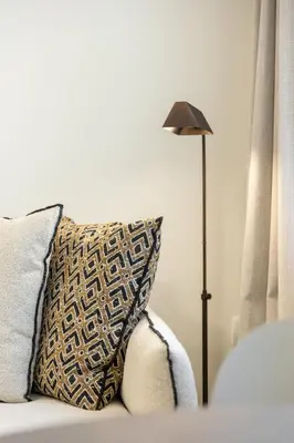 a pillow sitting on a couch next to a lamp at Terracotta Lofts in Athens