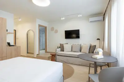 a white living room with a couch and a table at Terracotta Lofts in Athens