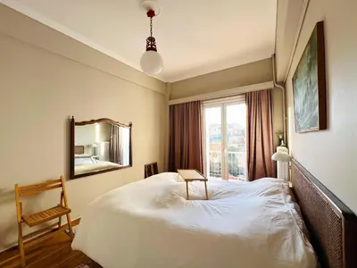 a bedroom with a bed and a mirror and a chair at 2BDR Central, Bright & Cosy Flat by the Acropolis in Athens