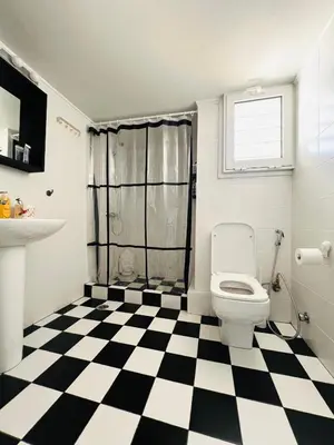a bathroom with a toilet and a black and white checkered floor at 2BDR Central, Bright & Cosy Flat by the Acropolis in Athens