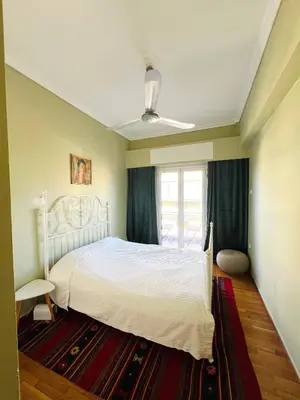 a bedroom with a white bed and a window at 2BDR Central, Bright & Cosy Flat by the Acropolis in Athens