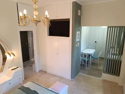 a living room with a chandelier and a table at Athens Royal Suite in Athens