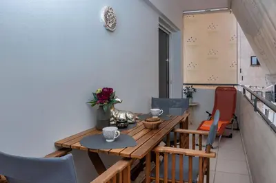 a balcony with a wooden table and chairs at Glyfada's Luxury Design Apartment with balcony in Athens