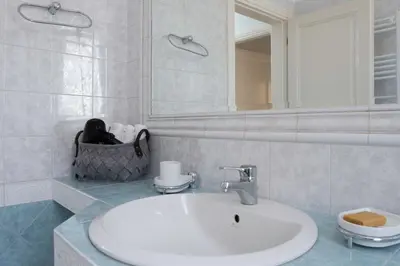 a white bathroom with a sink and a mirror at Glyfada's Luxury Design Apartment with balcony in Athens