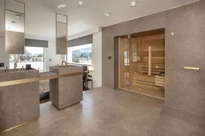a bathroom with a sink and a glass door at Luxury Loft Sauna HotTub Psyhiko in Athens