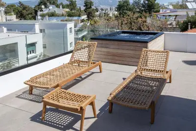 two wicker chairs and a bench on a balcony at Luxury Loft Sauna HotTub Psyhiko in Athens
