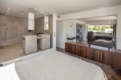 a bedroom with a large bathroom with a tub and a television at Luxury Loft Sauna HotTub Psyhiko in Athens