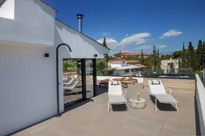 a patio with white chairs and a swimming pool at Luxury Loft Sauna HotTub Psyhiko in Athens