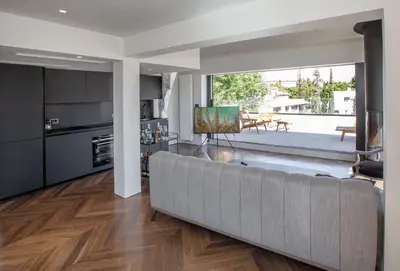 a living room with a large couch and a kitchen at Luxury Loft Sauna HotTub Psyhiko in Athens