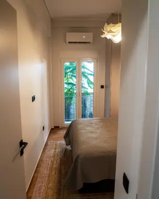 a bedroom with a bed and a large window at Kypseli urban Oasis in Athens