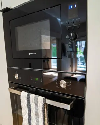 a black microwave oven with a towel on a rack at Kypseli urban Oasis in Athens