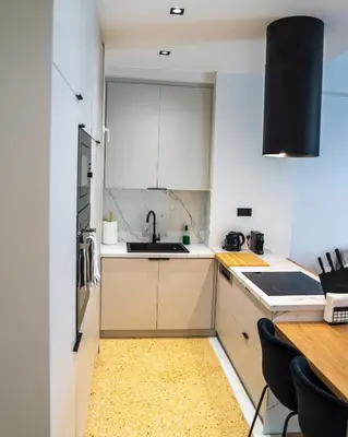 a kitchen with white cabinets and a sink at Kypseli urban Oasis in Athens