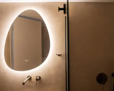 a bathroom with a round mirror on the wall at Kypseli urban Oasis in Athens