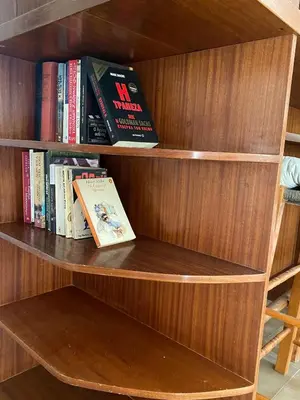a book shelf with books and a book at Glyfada Charm, Cozy & Warm with private parking in Athens