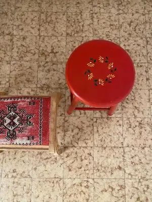a red chair sitting on the floor next to a rug at Glyfada Charm, Cozy & Warm with private parking in Athens