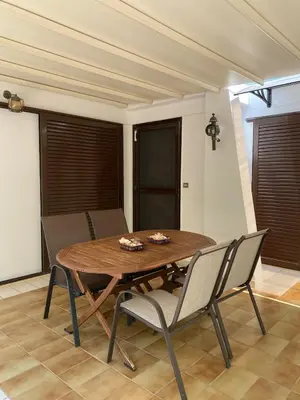 a wooden table and chairs in a living room at Glyfada Charm, Cozy & Warm with private parking in Athens