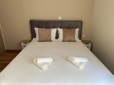 a bed with two towels on top of it at Διαμέρισμα κοντά στο μετρό - Flat next to metro in Piraeus