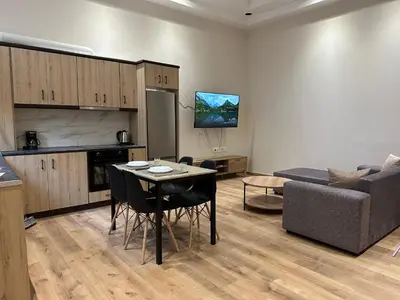 a kitchen and a living room with a table and chairs at Διαμέρισμα κοντά στο μετρό - Flat next to metro in Piraeus