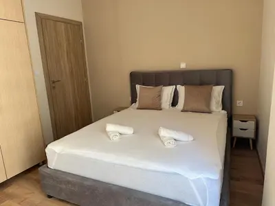 a bedroom with a large bed with two slippers on it at Διαμέρισμα κοντά στο μετρό - Flat next to metro in Piraeus