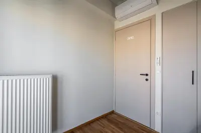 a hallway with a white door and a radiator at The Portside Getaway - 2BR, 2BA Duplex in Piraeus in Piraeus