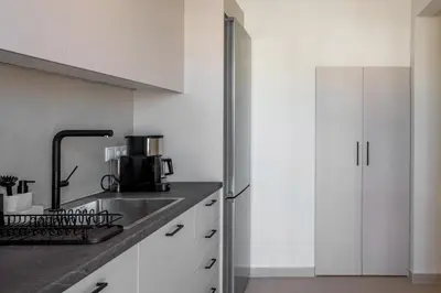 a kitchen with white cabinets and a refrigerator at The Portside Getaway - 2BR, 2BA Duplex in Piraeus in Piraeus