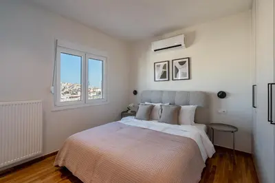 a white bedroom with a large bed and a window at The Portside Getaway - 2BR, 2BA Duplex in Piraeus in Piraeus