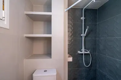 a bathroom with a shower and a toilet at The Portside Getaway - 2BR, 2BA Duplex in Piraeus in Piraeus