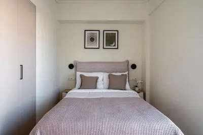 a white bedroom with a large bed with two pillows at The Portside Getaway - 2BR, 2BA Duplex in Piraeus in Piraeus