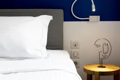 a bedroom with a white bed with a lamp on a table at Massive 2 Apartment Combo Unbeatable Acropolis Views Sleeps 9 in Athens