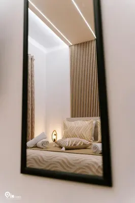 a mirror reflecting a bed in a bedroom at Danae's - Luxury & Modern Apartment in Egaleo-Athens in Athens