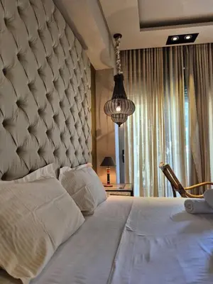 a bedroom with a large white bed with a large headboard at Modern Villa in the heart of Athens Riviera with garden in Athens