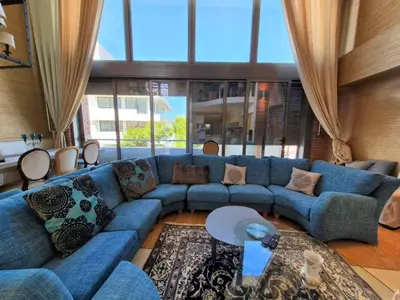 a living room with a blue couch and a large window at Modern Villa in the heart of Athens Riviera with garden in Athens