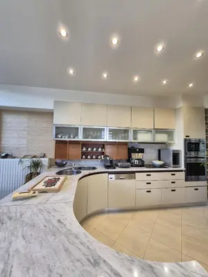 a large kitchen with white cabinets and a marble floor at Modern Villa in the heart of Athens Riviera with garden in Athens