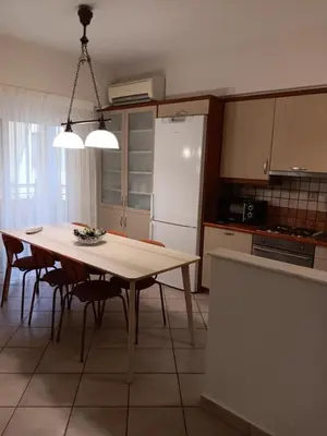 a kitchen with a table with chairs and a refrigerator at Casa Nikos in Athens