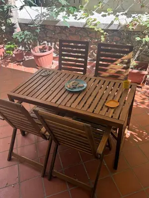 a wooden table and chairs with a plate on it at Casa Nikos in Athens