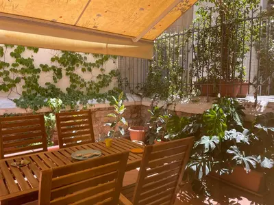 a patio with a wooden table and some plants at Casa Nikos in Athens