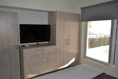 a living room with a tv and a window at Stergiou Luxury Apartments με κοινη πισινα in Saronida