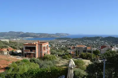 a building on top of a hill with a city at Stergiou Luxury Apartments με κοινη πισινα in Saronida