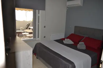 a bedroom with a bed and a view of a balcony at Stergiou Luxury Apartments με κοινη πισινα in Saronida